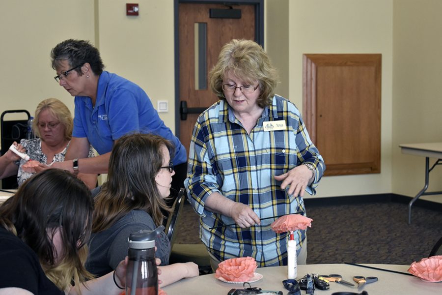 Tonya Morton, an employee of the Charleston Carnegie Public Library, teaches people how to use coffee filters to craft into flowers at the Rotary Room B Tuesday evening.

