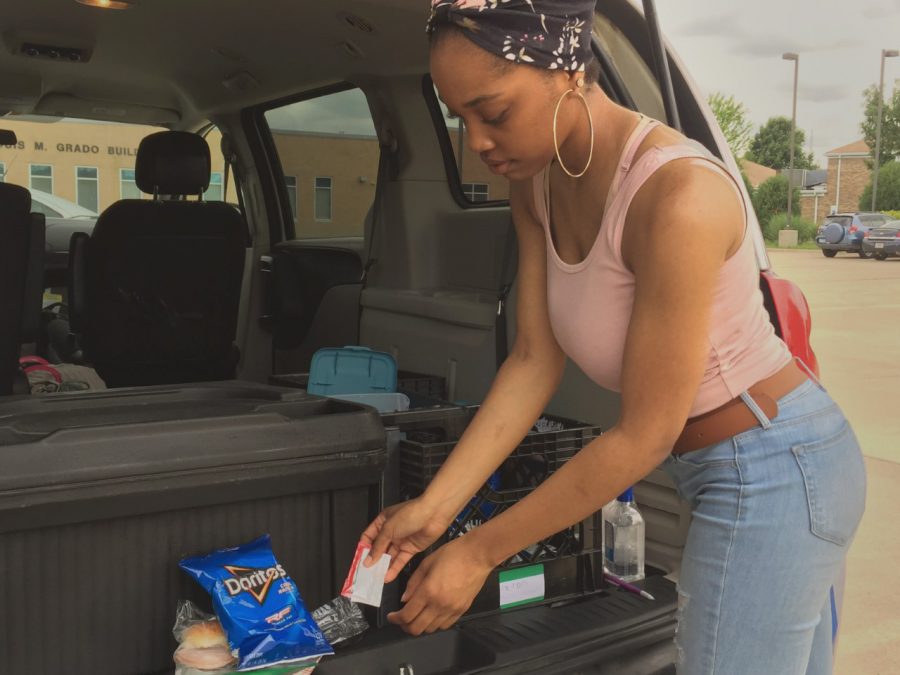 Monica Maybell, a dietetics senior and student worker, organizes a meal as part of the Office of Civic Engagement and Volunteerism and Salvation Armys summer free meals program for youth on Wednesday at Textbook Rental.