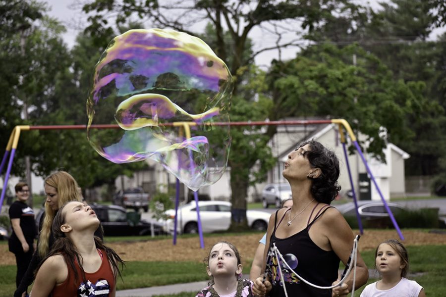 Rae Spooner from Danville, Ill blows bubbles with children Wednesday afternoon at Morton Park during the Red, White and Blue Days. Spooner said about 20 children were participating in the bubble blowing Wednesday.