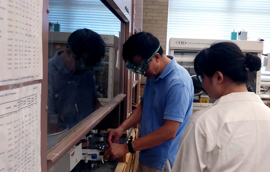 Hongshan He (left), a chemistry professor, instructs Beibei Liu, a research assistant, on how to use a spin coater in the Physical Sciences Building Monday afternoon.