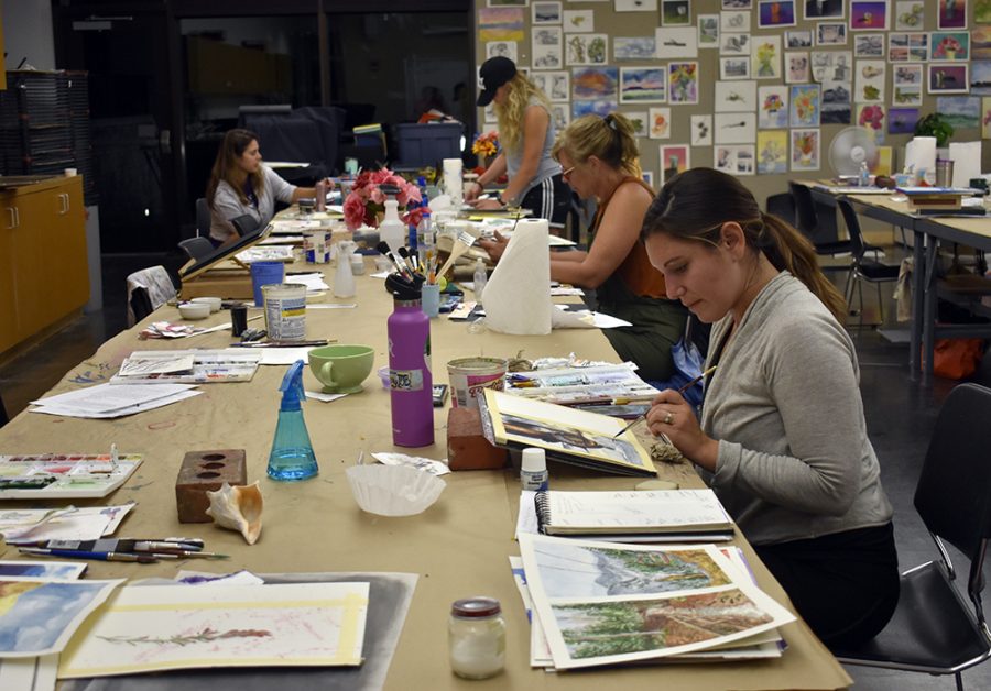 Graduate art education students paint watercolor in room 2690 at the Doudna Fine Arts Center Wednesday night.