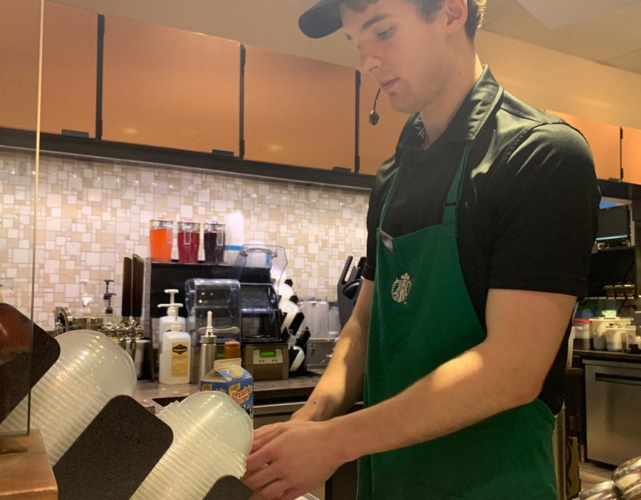 Shawn Walker, a senior kinesiology major, makes a drink at Starbucks Monday night.