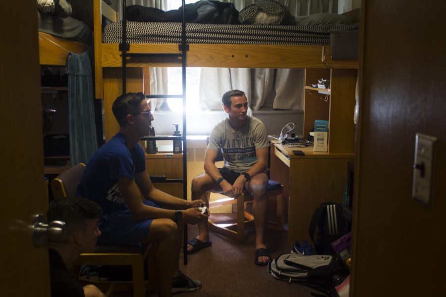 David Thomas (left), a junior physical education major, Adam Swanson (middle), a freshman criminal justice major and Nathan Jones (right), a sophomore computer science major, are settled in and playing video games after moving in on Thursday.