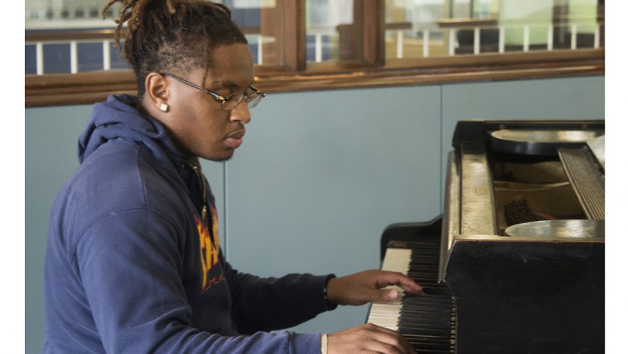 Ozzie Gardner, a freshman whose major is undecided, plays a melody on the piano in the lobby of Lawson Hall on Thursday afternoon.
