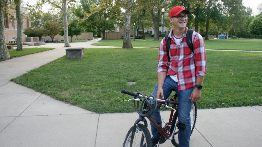 Matthew Riley, a sophomore double majoring in psychology and criminology, stops on his bike to say hi to a friend Monday at the Library Quad. Riley said he rides his bike everywhere on campus every day. 