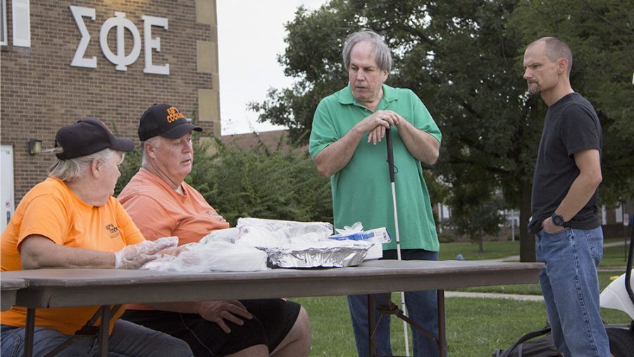 Jan (far left) and Gary Kepley (left), owners of Kep’s Cooking, talk to BJ Fessant (right) and DJ Danny Wayne (far right), who both work for DJ Danny Wayne and Associate, before the movie “Captian Marvel” in the Greek Court parking lot Thursday evening. The Kepleys, Fessant and Wayne said they have been at different events for Eastern in the past and love coming out to them.