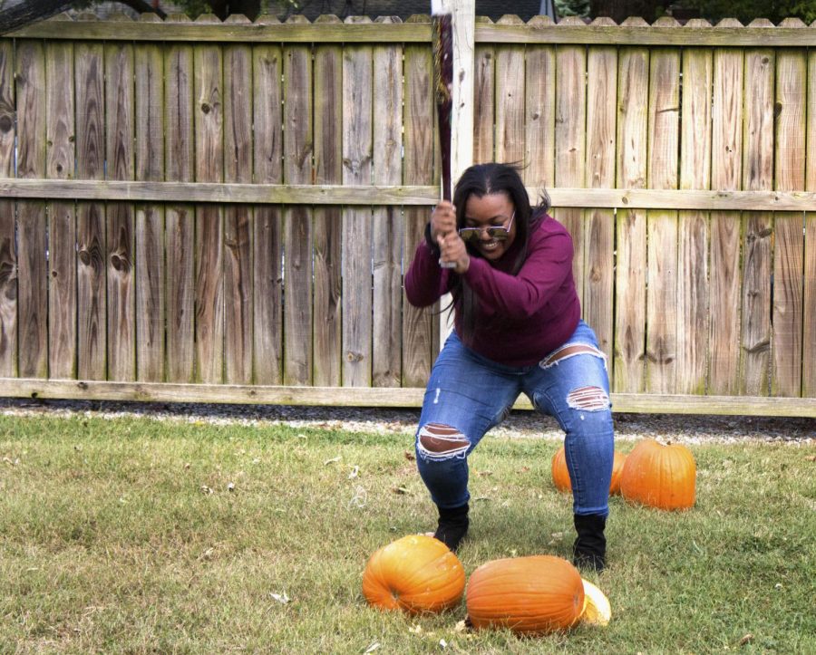 Courtney Cager, a junior accounting and fashion merchandising major, smashes pumpkins with Alpha Sigma Alpha, Alpha Sigma Tau and Kappa Delta to help with Phi Kappa Theta’s philanthropy project on Thursday evening at Ninth Street. “I love helping out other Greek’s philanthropy on campus while spending time with my sisters,” she said.