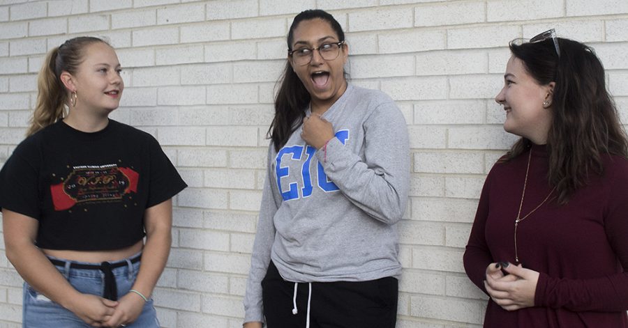 Elizabeth Houk (left), a sophomore graphic design major, Fatima Estrada (center), a sophomore with an undecided major, and Grace Osborn (right), a junior biochemistry major describe each other’s personalities Wednesday afternoon outside of the Tarble Arts Center. Osborn was describing Estrada’s personality and said she was amazing even though she denies it, causing Estrada to grab her collar and gasp.