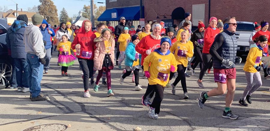 Community members run on the corner of Broadway Street and 16th Street in Mattoon, where The Girls on the Run 5K running route began, Saturday morning. The run had approximately 400 race participants.