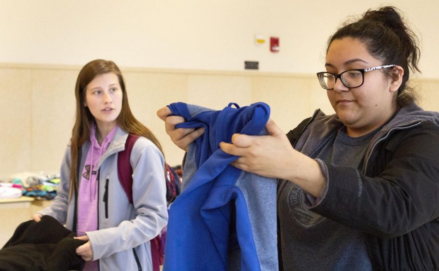 Alyssa Bettenhausen (left), a sophomore majoring in biological sciences with an emphasis in veterinarian medicine, and Lizette Aguilera (right), a junior environmental biology major, look at clothes at the “EIU: Swap and Share” event organized by the Environmental Health and Sustainability class in the Martin Luther King Jr. University Union on Tuesday afternoon. During the event, students in the environmental health and sustainability class handed shoppers T-shirt bags to reduce plastic waste. 