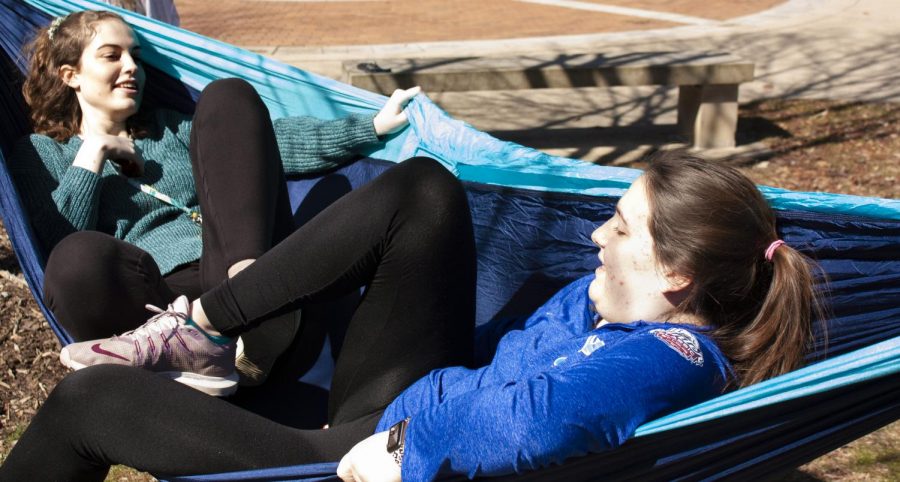 Caleigh Miller, a freshman sports management major, and Kristina Robinson, a freshman communication disorders and sciences major, relax in a hammock outside of the Library Quad Thursday afternoon. Miller and Robinson were hanging out in the hammock while their friends played music and chatted with them from a nearby bench.