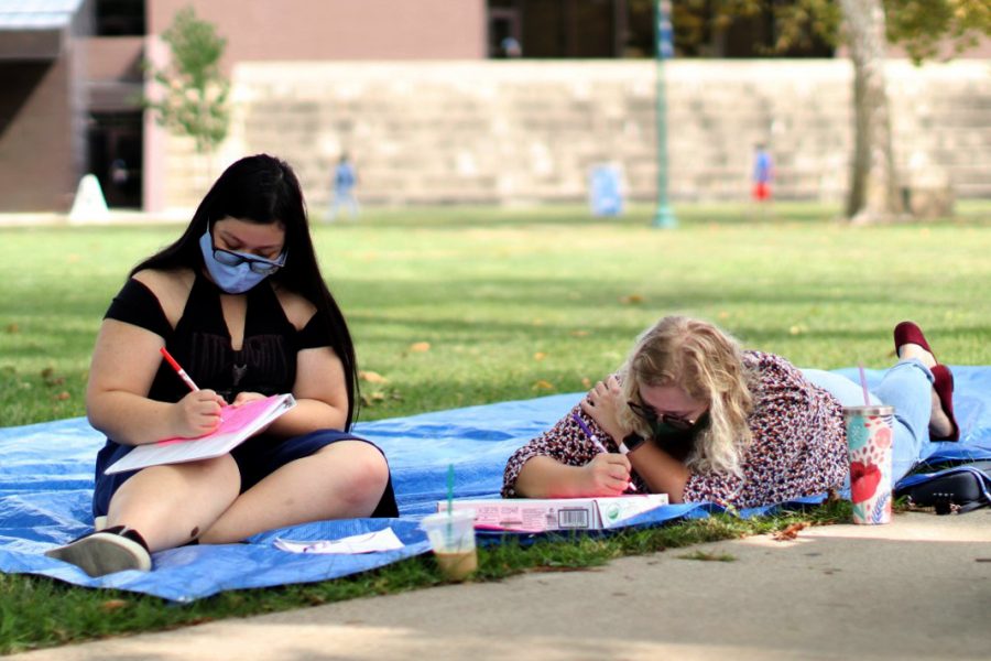 Victoria Tegge (left), a nutrition and dietetics major, and Olivia Triplett, an elementary education major, color together in the North Quad on Monday afternoon. 