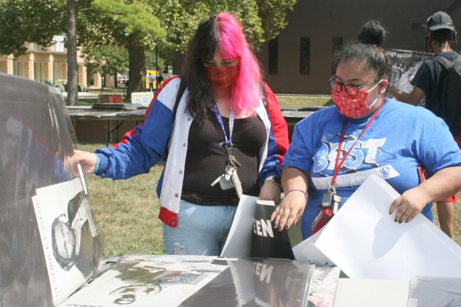 Kathya Morales (left) a freshman history education major, and Jacky Rivera (right) a freshman elementary education major look through posters at the Library Quad Tuesday afternoon. Morales and Rivera said they were walking around campus and decided to check out the poster sale after seeing the set up.
