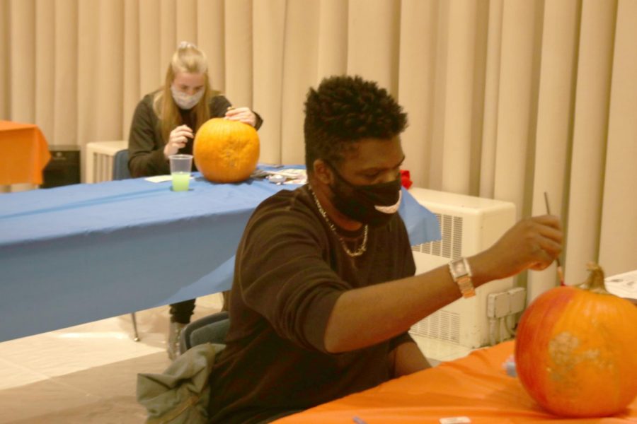 Frederick+Davis%2C+a+sophomore+video+game+production+major%2C+paints+a+pumpkin+for+the+Pumpkin+Paint+%26+Sip+event+hosted+in+the+University+Ballroom.+Students+were+provided+a+pumpkin+and+a+painting+kit+to+compete+for+1st%2C+2nd%2C+and+3rd+place+prizes.%0A