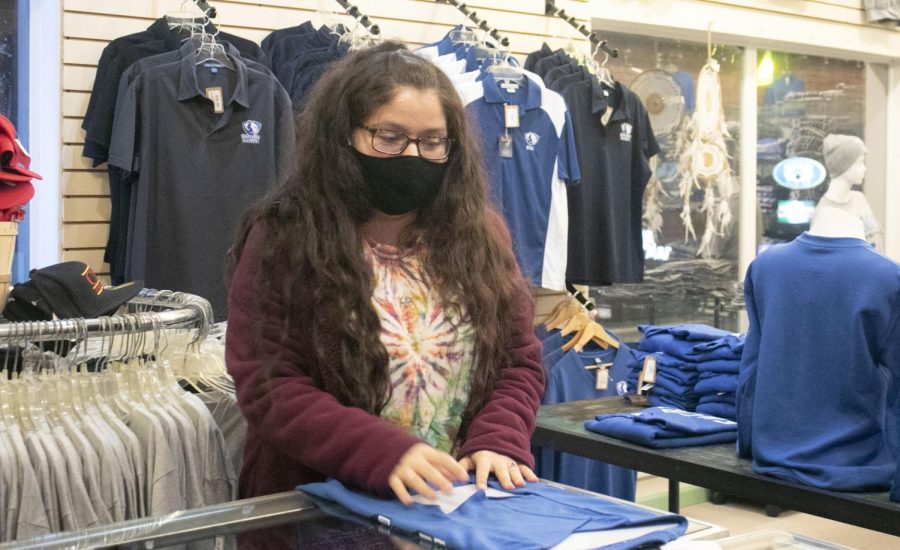 Desiree Theobald, a senior public relations major, folds t-shirts at Positively 4th Street Records Monday night. Theobald said she has been working at 4th Street for two years. “I really do enjoy it, Theobald said. She also said she enjoys the holidays, homecoming events and state track season in the shop.