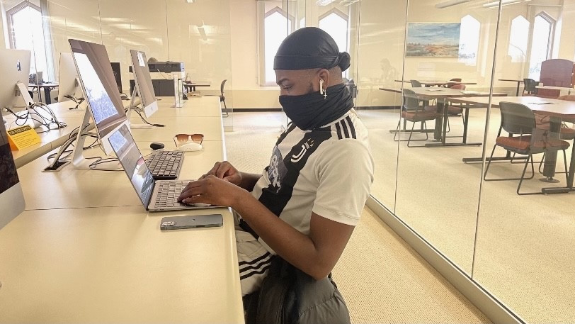 Cedrich Soglohoun, a senior marketing major, takes care of some schoolwork at Booth Library Tuesday afternoon. “I am more focused and get work done when I’m at the library,” Soglohoun said.