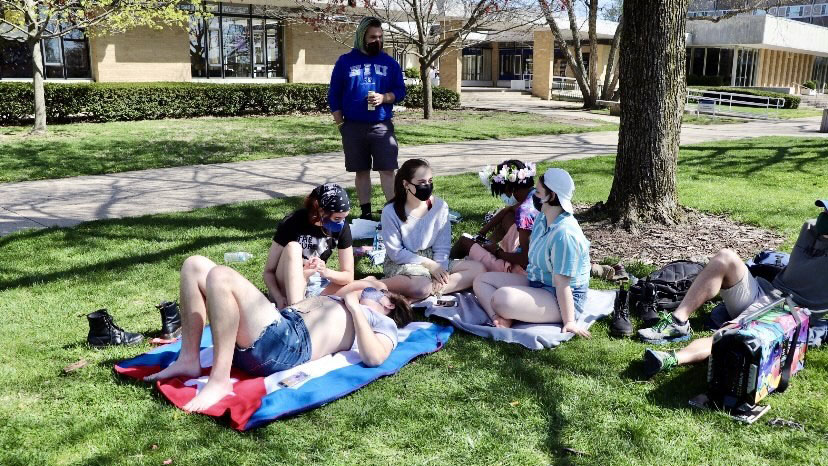 A group of students relax on the South Quad and listen to music while enjoying the weather on Friday. Many students have been spending more time outside as the weather continues to warm up. 