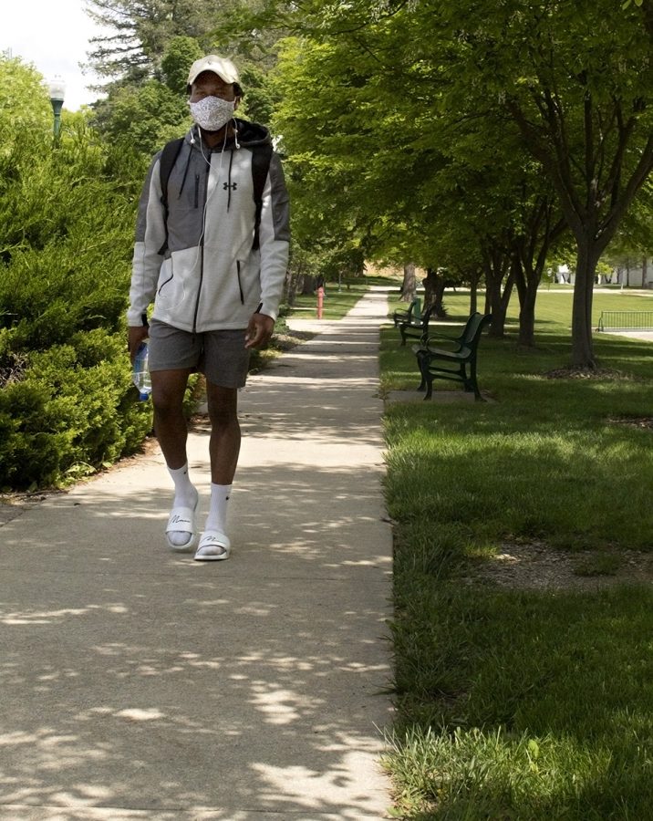 Tadz Mhonde, a recent graduate, walks across campus on Thursday afternoon. Mhonde said he was taking a moment to walk around campus before he begins his work as a graduate student in the fall. He said he was excited to graduate and that it felt freeing.