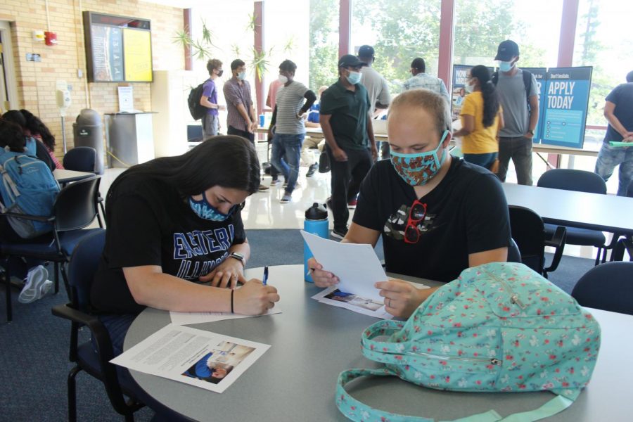 Audrey Buss, a freshman science education major, fills out a job application while her husband, Luke Mason, is there to support her.