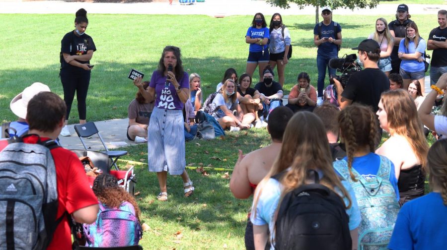 Sister Cindy preaches and tells stories about her life to students listening in library quad in front of the Mellin steps.