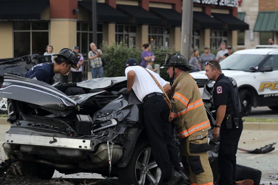 Members from the Charleston Fire Department and Police Department searach the car of the deceased man who drove onto oncoming traffic to cause the five-car accident that happened an the intersection of Lincoln Avenue and University Drive on Sept. 19, 2021.