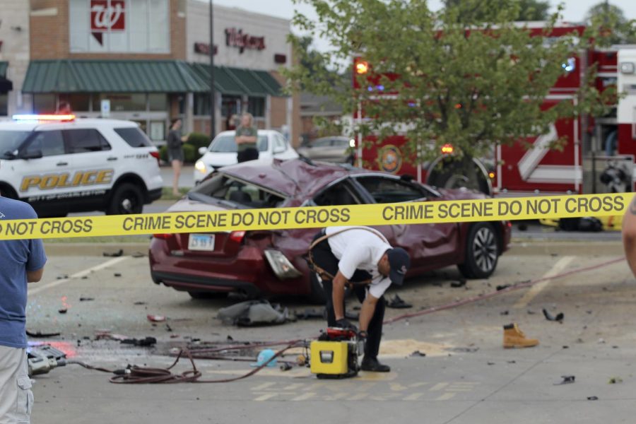 A member of the Charleston Police Department picks up debris from the five-car accident that happened on the intersection of Lincoln Ave. and University Drive on Sept. 19, 2021. 