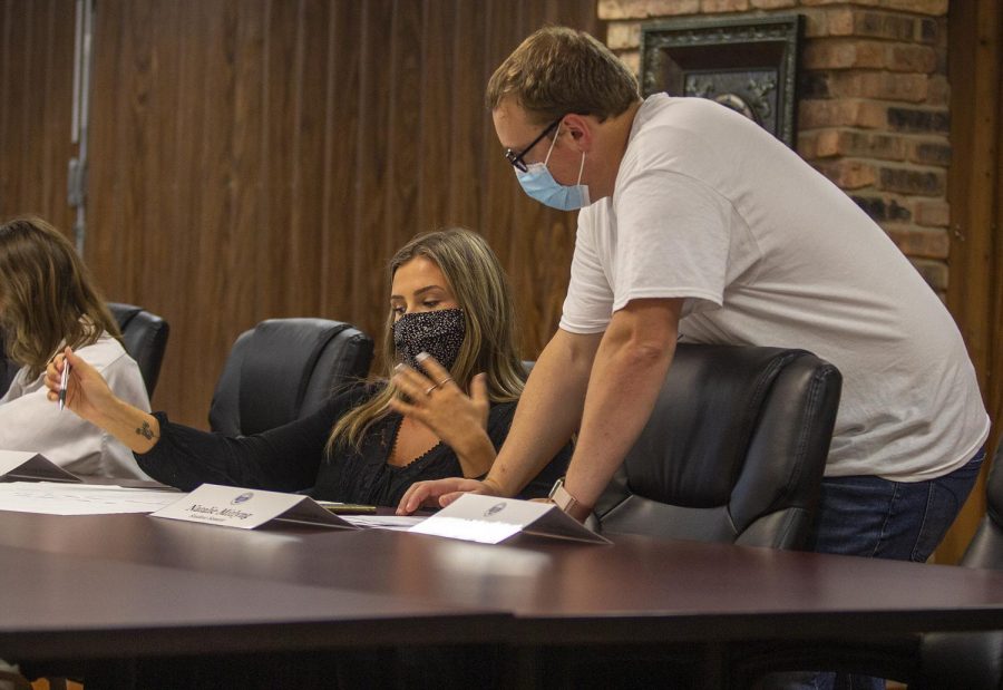 Graduate adviser Justin Richards who studies communications helps student senator Natalie Mitlyng, a senior pre-veterinary biology major with ideas on possible events for their department to run at the Oct. 5 Student Government meeting. 