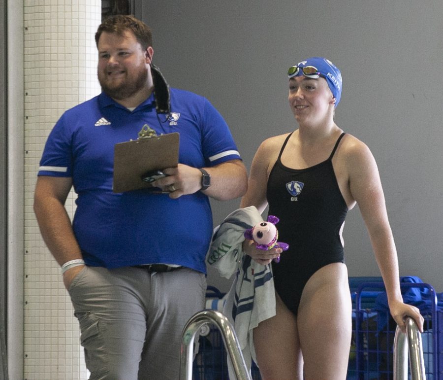 Eastern head swimming coach Tyler Donges (left) watches and event with swimmer Emma Keith during Easterns meet against Evansville on Oct. 9 in Padovan Pool.