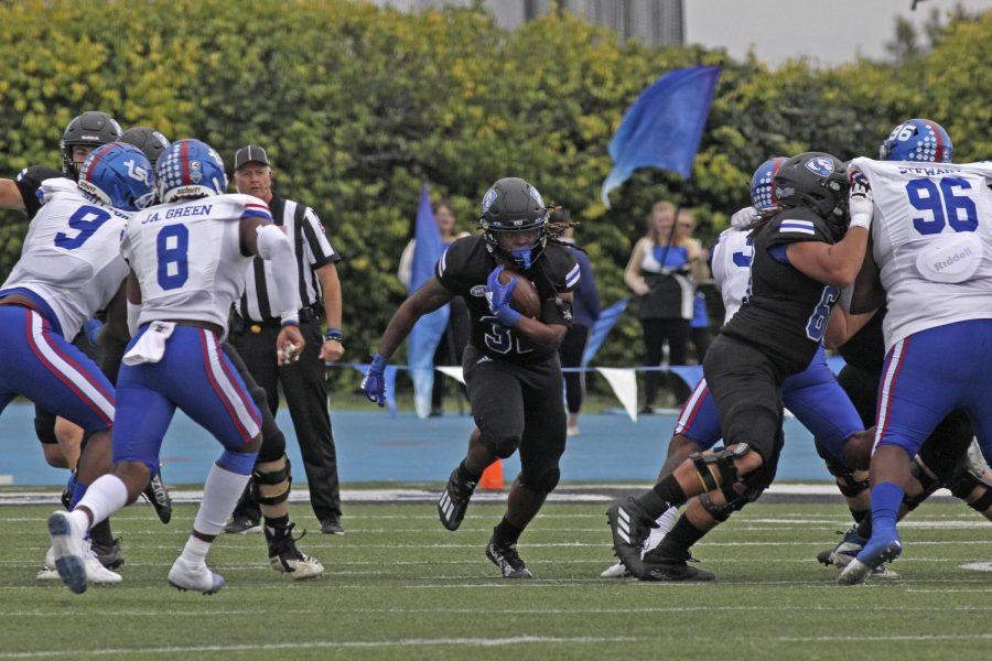 Eastern running back Harrison Bey-Buie (center) runs the ball past the Tennessee State defensive line. Bey-Buie ran a total of 33 yards in Saturday afternoon’s game at O’Brien Field. Eastern lost the game 28-0 to Tennessee State.