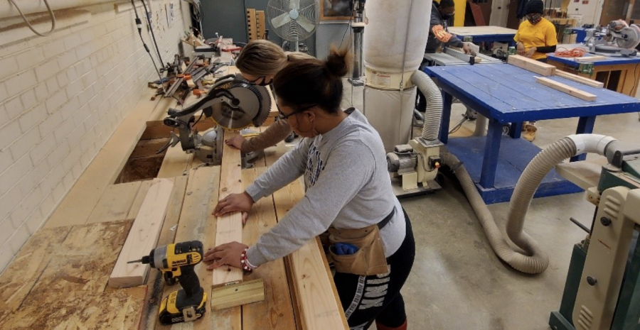 Raven Ramsey, senior construction management major and Katherine Farrell, a graduate student studying sociology, cut wood in a project for the Construction Club.