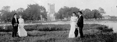 Two couples posed by Lake Ahmoweenah, with Old Main in background, July 1902. Pictured from left to right are Frank Henderson, Ethel Carnes, Grace Moore, and Charles Henderson.