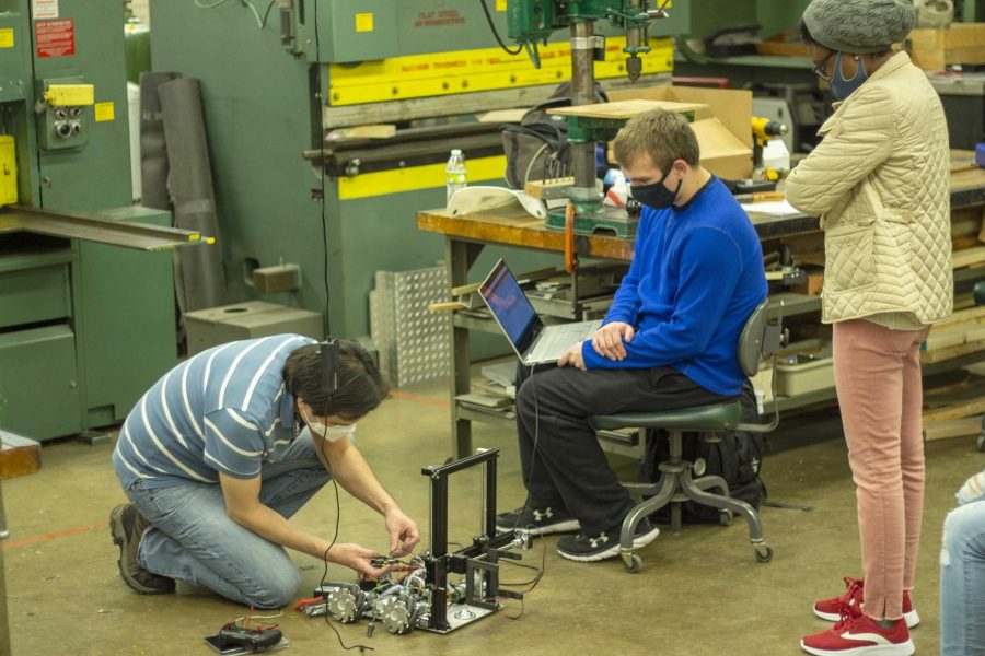 Wutthigrai Boonsuk, who has a doctorate in industrial and manufacturing systems engineering, helps with the robotics team’s robot for The Association of Technology Management, and Applied Engineering annual competition in Orlando, Florida. The competition will be held Wednesday to Friday; the robotics team will leave Thursday. Robotics Club members Caden Miller, a senior computer info technology major, and Grace Fosu, a graduate student studying technology, watch as Boonsuk tests and adjusts their robot. Miller worked on the coding for the robot.