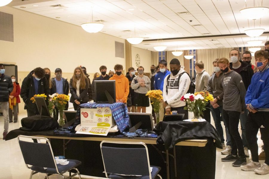 Students gather around Jason Aguilar’s ofrenda to honor his memory during the Dia de los Muertos ofrenda exhibit inside the University Ballroom of the Martin Luther King Jr. University Union.