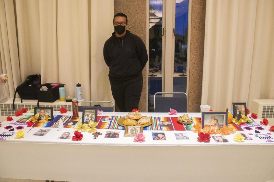 Christian Watson, a sophomore spanish teacher licensure major, shows off the ofrenda he and his other group members put together for the Dia de los Muertos ofrenda exhibit inside the University Ballroom of the Martin Luther King Jr. University Union.