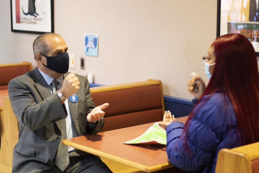 Abiah Jackson, a junior criminal justice major, plays rock, paper, scissors, against President Glassman at the University Food Court to win prizes for the Bonding with the Prez event hosted by Student Government. 