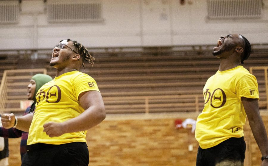 Kris Gross, (left) a sophomore sport management major, and Leon Lomax, (right) a junior digital media technology major, yell in excitement after being revealed during the Neophyte Presentation presented by Iota Phi Theta Fraternity Incorporated in McAfee Gym Dec. 3.