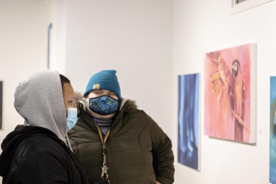 Michael Ford, a senior 2D studio art major, and Dorothy Wrausmann, a senior 2D studio art major, admire the art being showcased in the advanced painting show in the Glenn Hild Student Art Gallery inside Dounda Fine Arts Center on Dec. 9. 