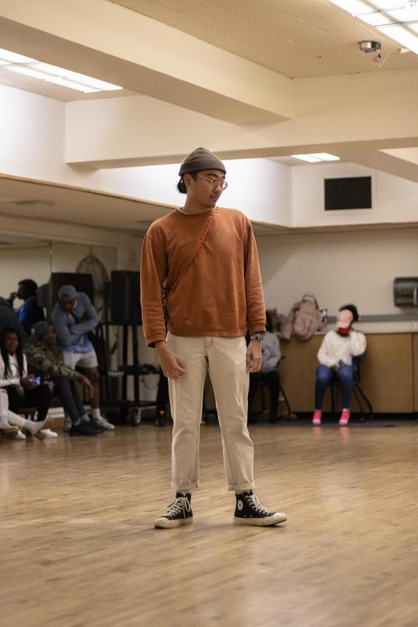 Kyle Ignalaga, a senior computer information technology major, poses in front of the crowd and judges during a modeling audition event hosted by Femi Usikalu, a senior digital media major, in McAfee Gym Thursday night. 