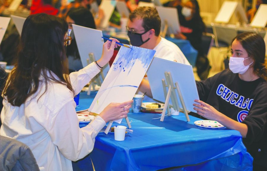 Grace Witzig, a freshman communications disorders and sciences major, Jonathan Coffin, a freshman pre-nursing major, and Callista Denoyer, a freshman chemestry major paint at the UB Express Yourself! Paint-N-Sip mixer, for part of the Winter Welcome Days, at the University Ballroom in the Martin Luther King Jr. Union Monday, Jan. 10, 2022. 