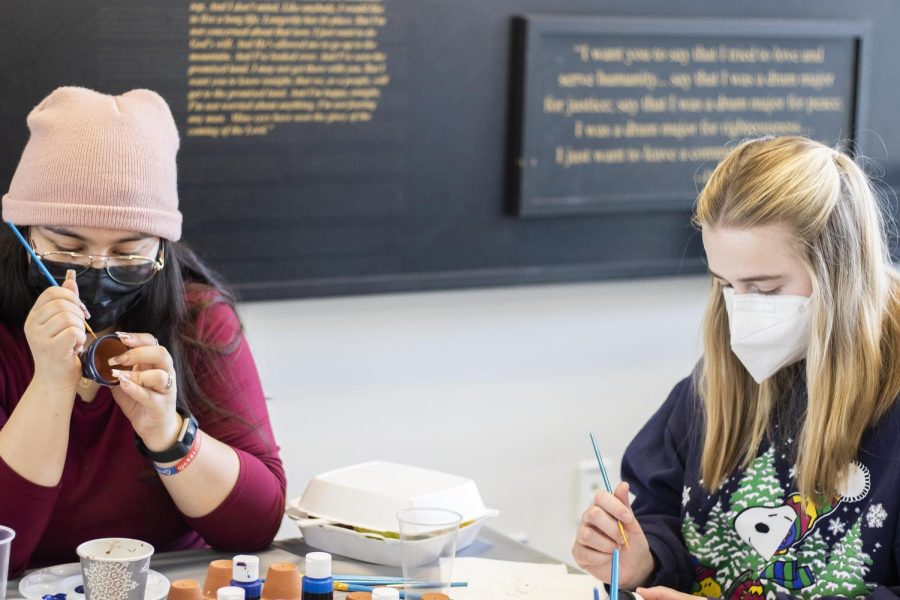 Kristal Munos, a junior criminology and criminal justice major, and Brittany McMinn, a sophomore accounting major, paint tiny plant pots and snowmen at the Winter Welcome Dayz event in Martin Luther King Jr. University Union on Wednesday afternoon. 