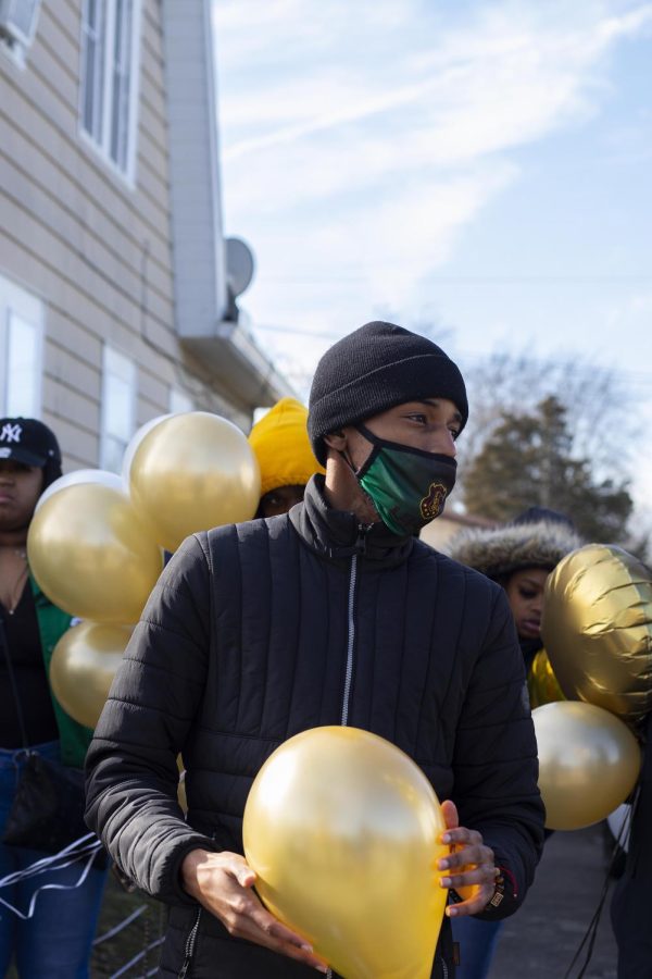 Dj Jones, a senior digital media and graphic design major, and member of Iota Phi Theta Fraternity Inc., shares memories of Kristian Philpotts and gets ready to release balloons in honor of him on Saturday afternoon.