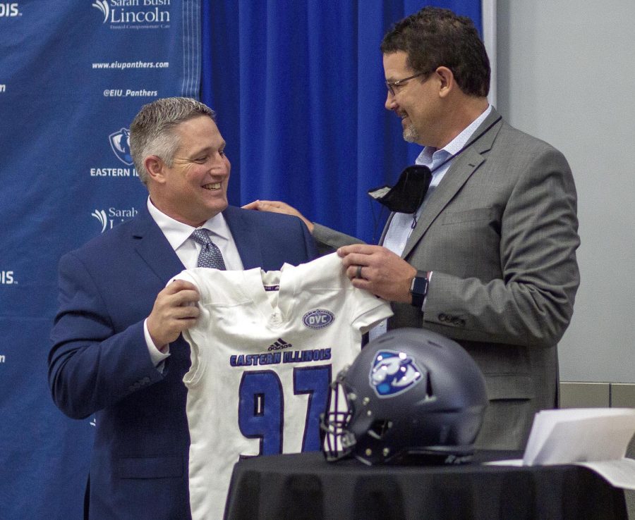 From left, Chris Wilkerson, Easterns newest head football coach, receives a jersey from EIU Athletic Director Tom Michael for becoming the football team’s new head coach at WIlkerson’s press conference on Friday in the Hall of Champions in Lantz Arena. 