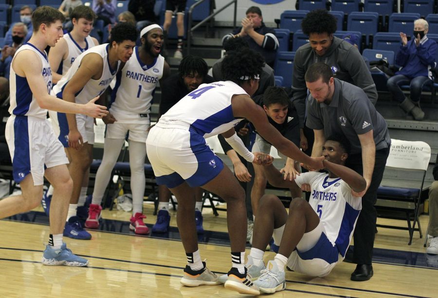 Paul Bizimana, a freshman forward, gets picked up by his teammates after making a late basket in the men’s basketball game on Saturday against Tennessee State Tigers at Lantz Arena. Bizimana had 20 points and 6 rebounds. The Panthers won 62-57 against the Tigers.
