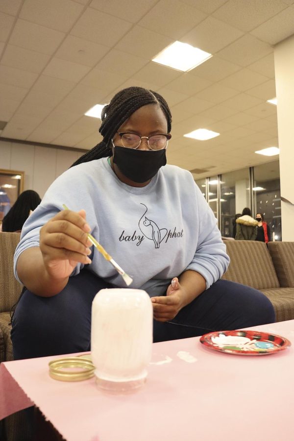 Tasima Allen, a junior theatre major, starts to paint her mason jar for Andrews Hall’s mason jar painting event Monday night as a way to destress and express during the school week.