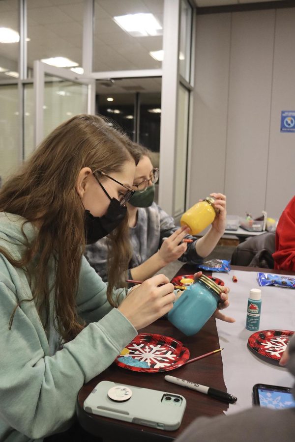 Ashley Mlinar, a freshman studio art major, and Brook Ozier, a freshman biology major, decorate mason jars together.