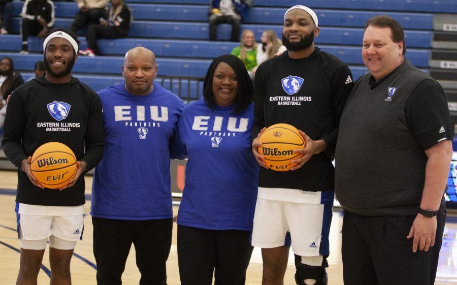 Eastern guard Kashawn Charles (left) and forward Sammy Friday IV (second from right) pose with head coach Marty Simmons (right) and Fridays parents prior to the mens basketball game on Feb. 26 in Lantz Arena. It was Senior Day for the Panthers, and Charles and Friday were honored with a ceremony on the court. Friday scored 13 points and Charles scored eigth points in the game, which the Panthers lost 64-52.