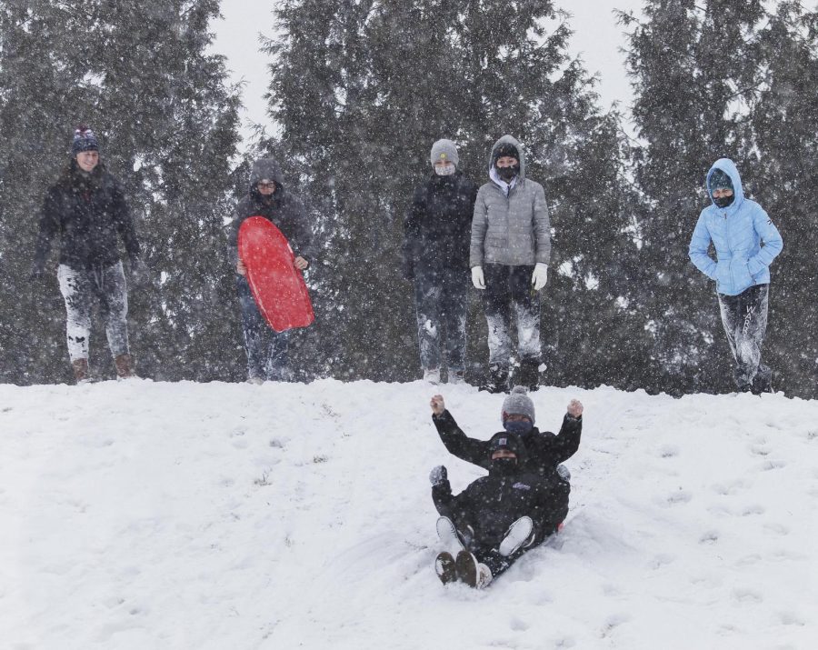 Since classes were cancelled due to the weather, a group of students go take some time to go sledding on top of a hill behind Taylor Hall on Wednesday afternoon.