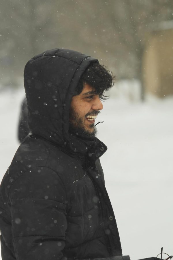 Venkata Goluguri, a graduate student studying computer technology, talks with his friend and has fun during a snowball fight in the library quad.