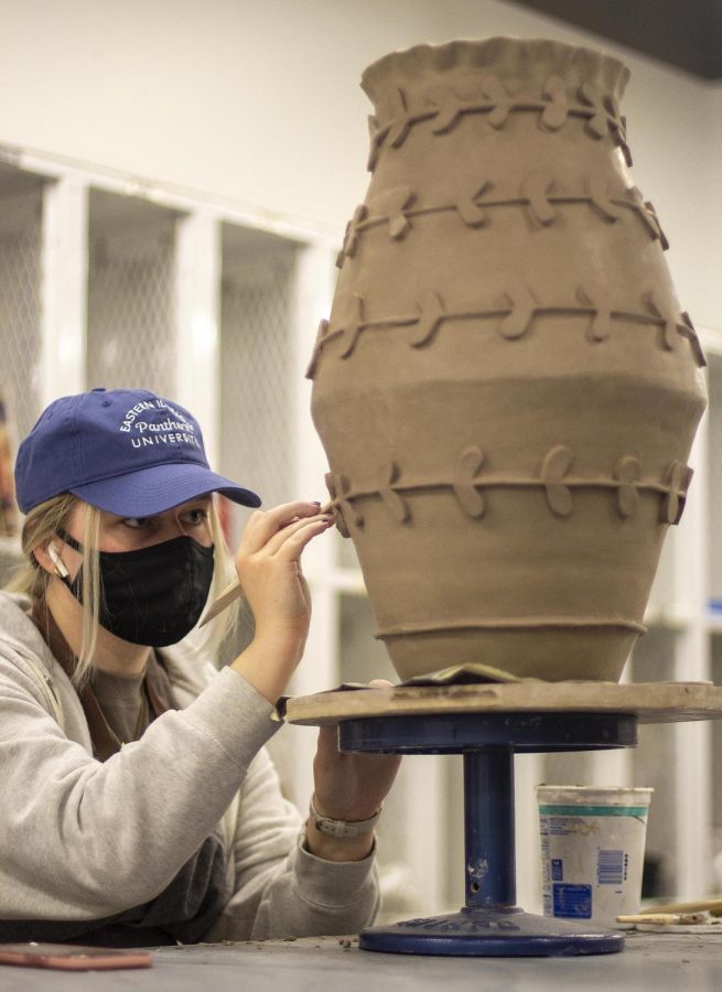 Lainey Banta, a junior art education major, sculpts a coil pot in Doudna on Friday. The piece is called “Tessy” and derives from the phrase “two-ton Tessy” because it is heavy. The pot is 22 inches tall and weighs around 10 pounds. 