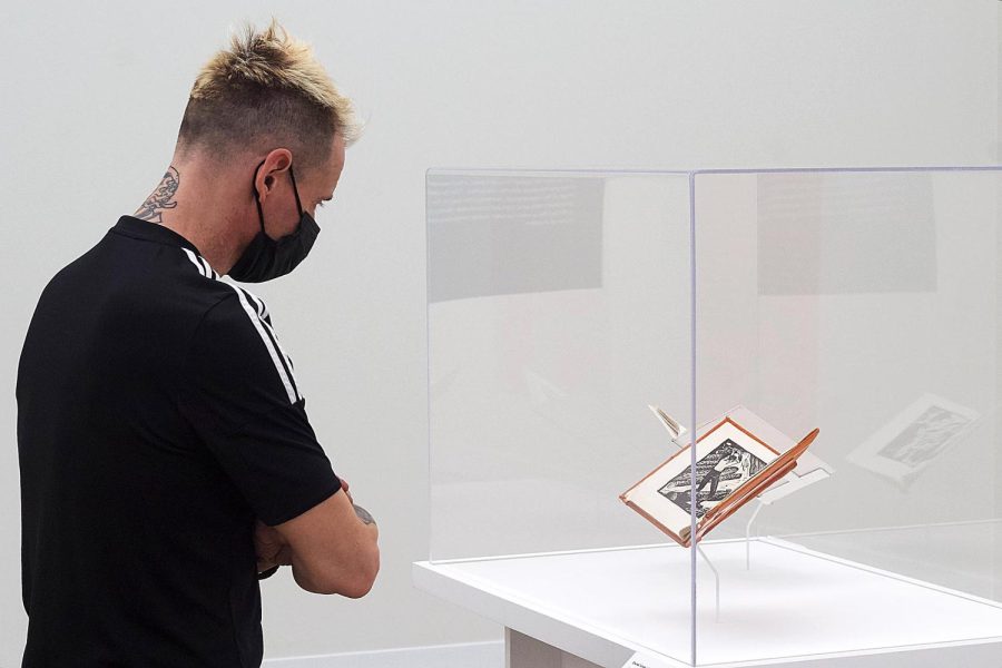 Tarble Arts Center Assistant Director and Exhibitions Curator Mike Schuetz, looks at the Abraham Lincoln Biography, in woodcuts that is part of the Working Artists Exhibit on Feb. 14. 